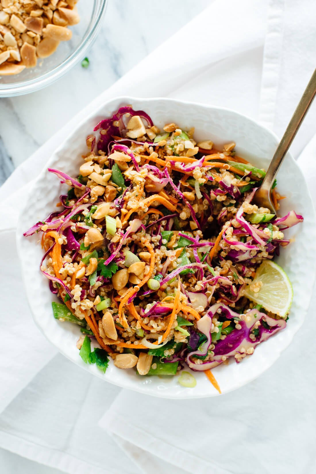 You're going to love this colorful, crunchy Thai peanut quinoa salad! It's made with carrots, cabbage, snow peas, and quinoa, tossed in a delicious peanut sauce. It packs great for lunch. Vegan and gluten free. cookieandkate.com
