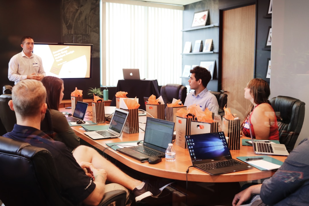 Team members collaborating in an office conference room discussing essential features to look for in a knowledge management tool