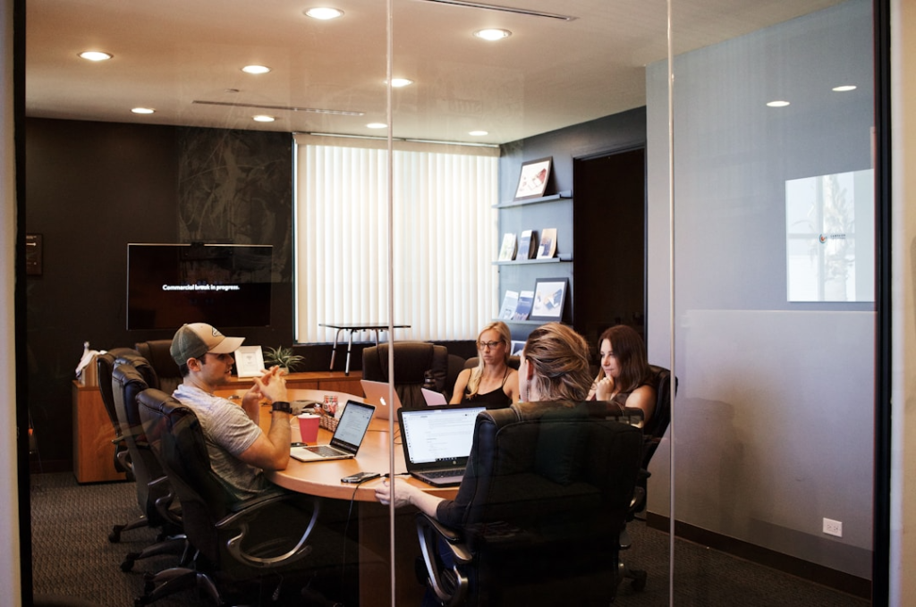 Team members collaborating in an office conference room evaluating usability and user adoption in knowledge management systems