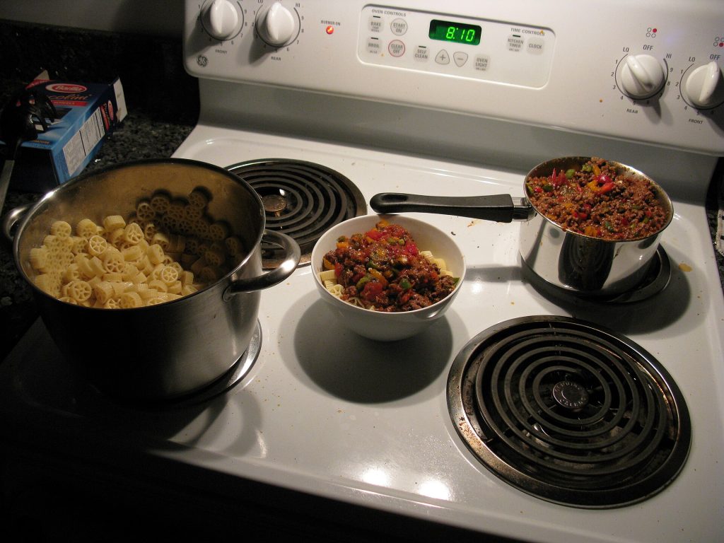 A pot of beef chili simmering on a stovetop