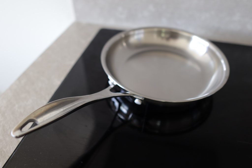 A stainless steel frying pan with a pan sauce