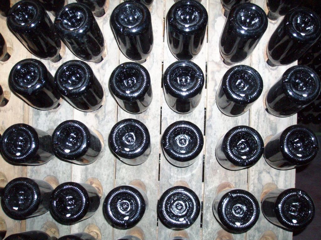 Sparkling wine bottles resting neck-down in a riddling rack