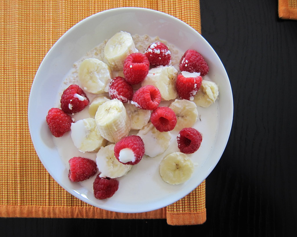 Bowl of oatmeal topped with fresh raspberries