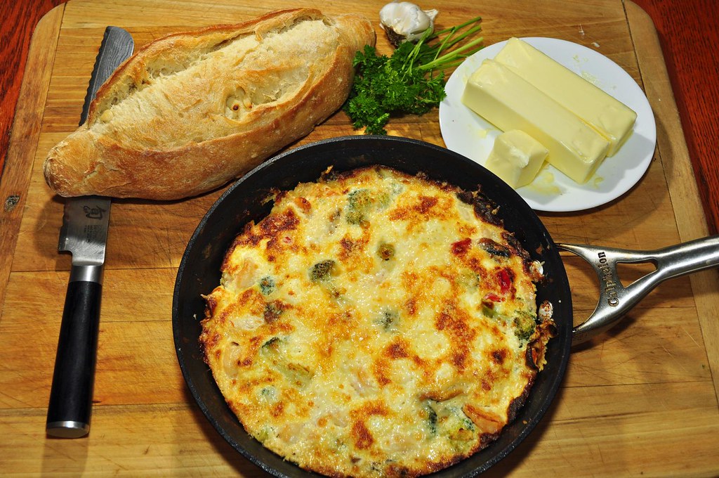 A vegetable frittata cooking in a cast iron pan