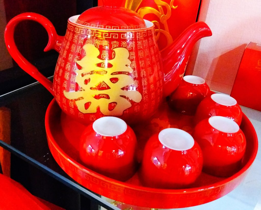 A Chinese teapot with small tea cups on a restaurant table
