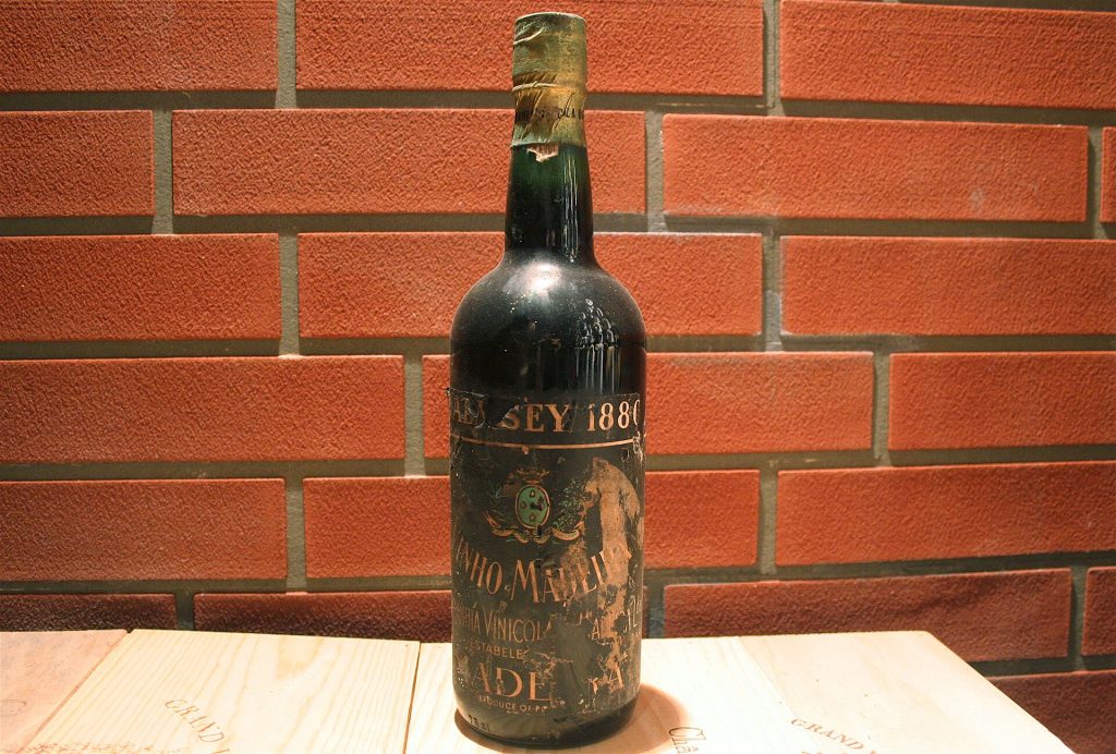 A bottle of Madeira wine with a filled glass