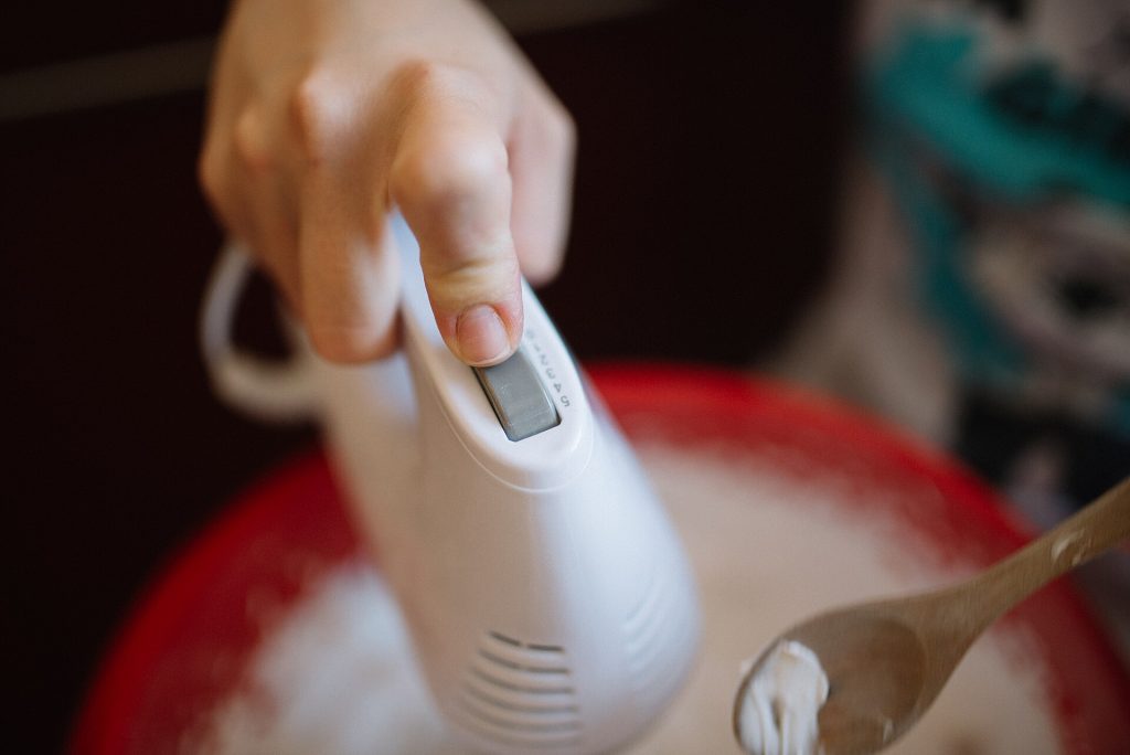 A hand mixer whipping batter in a mixing bowl