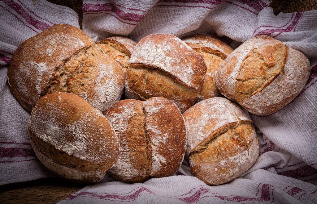 A smooth ball of kneaded bread dough on a floured surface