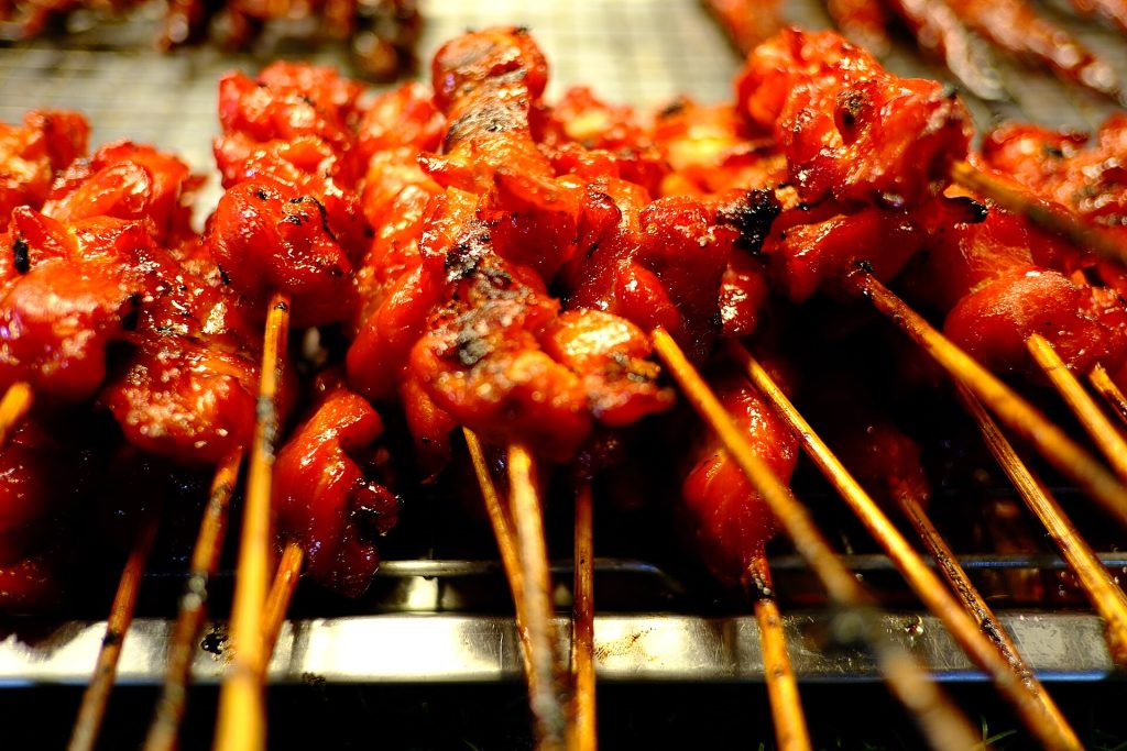 Chicken yakitori skewers cooking over a charcoal grill
